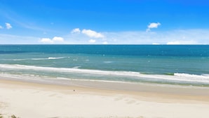 Ein Strand mit klarem, blauem Wasser und sandigem Ufer.