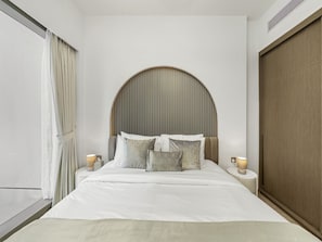 A modern bedroom with a large bed, a curved headboard, and two bedside lamps.