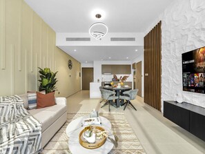 A modern living room with a sofa, coffee table, and a dining area with chairs.