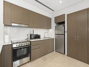 Eine moderne Küche mit Backofen, Mikrowelle und einem Kühlschrank aus Edelstahl.