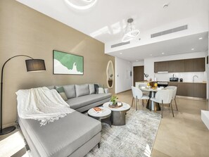 A modern living room with a sofa, coffee table, and dining area. - New 1BR |Burj Khalifa Infinity Pool |Dubai Mall (Dubai)