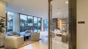 A modern hotel room with a large window, a seating area with sofas and a coffee table, and a small side table. - New 1BR | Burj Khalifa Infinity Pool | Dubai Mall (Dubai)
