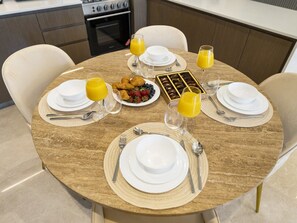 A breakfast setting with a round table, white plates, cutlery, and a box of chocolates. - New 1BR | Burj Khalifa Infinity Pool | Dubai Mall (Dubai)