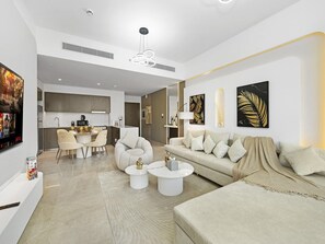 A modern living room with a sofa, coffee table, and a dining area with chairs.