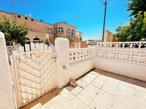 A gated courtyard with a tiled floor and a white decorative fence.