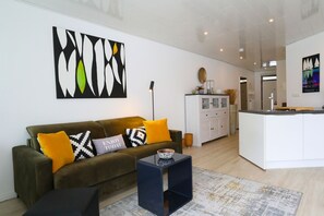 Una sala de estar moderna con un sofá, una mesa de centro y una obra de arte en la pared.