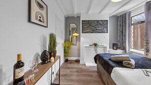 Une chambre à coucher moderne avec un lit, une table de chevet et une fenêtre avec des rideaux.