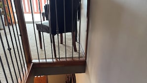 A staircase with a wooden handrail and a black chair on the landing. - Large Charcter Home  (Moose Jaw)