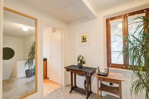 Cozy living space with a wooden floor, dark table, and framed artwork.