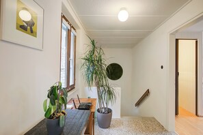 Enjoy meals and gatherings in a comfortable dining area with a wooden table and chairs, surrounded by a potted plant.