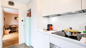 A compact kitchen with a built-in stove, a microwave, and a refrigerator. - La Canonica Centovalli with Balconies and Garden, Camedo, Switzerland (Camedo)