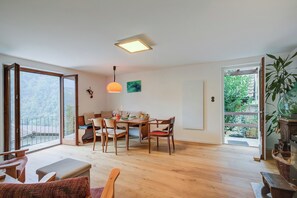 Relax in this stylish living space with a dining table, sofa, and balcony access.