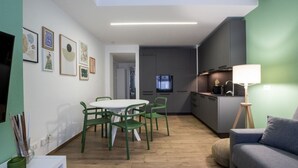 A modern kitchen with a dining area, a sofa, and artwork on the walls. - Gorki 11 Modern Escape (Milano)