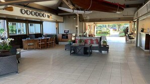 En rummelig lobby med receptionsdisk, siddeområde og store vinduer.