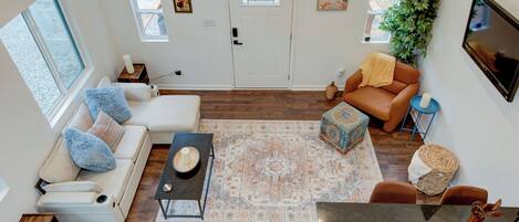 A living room with a sofa, a coffee table, a rug, a fireplace, and a television.