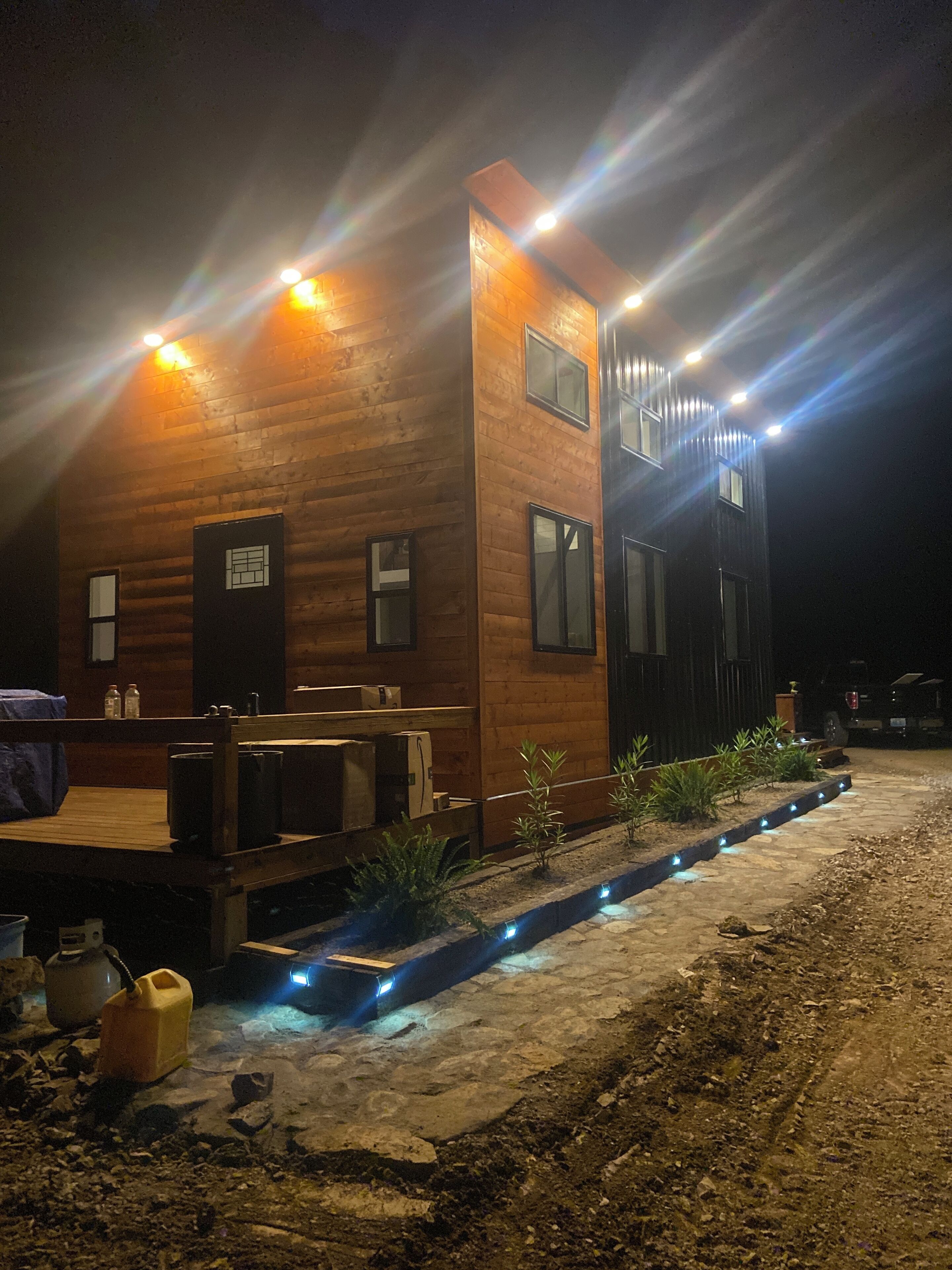 A two-story wooden cabin with a deck and outdoor seating area.
