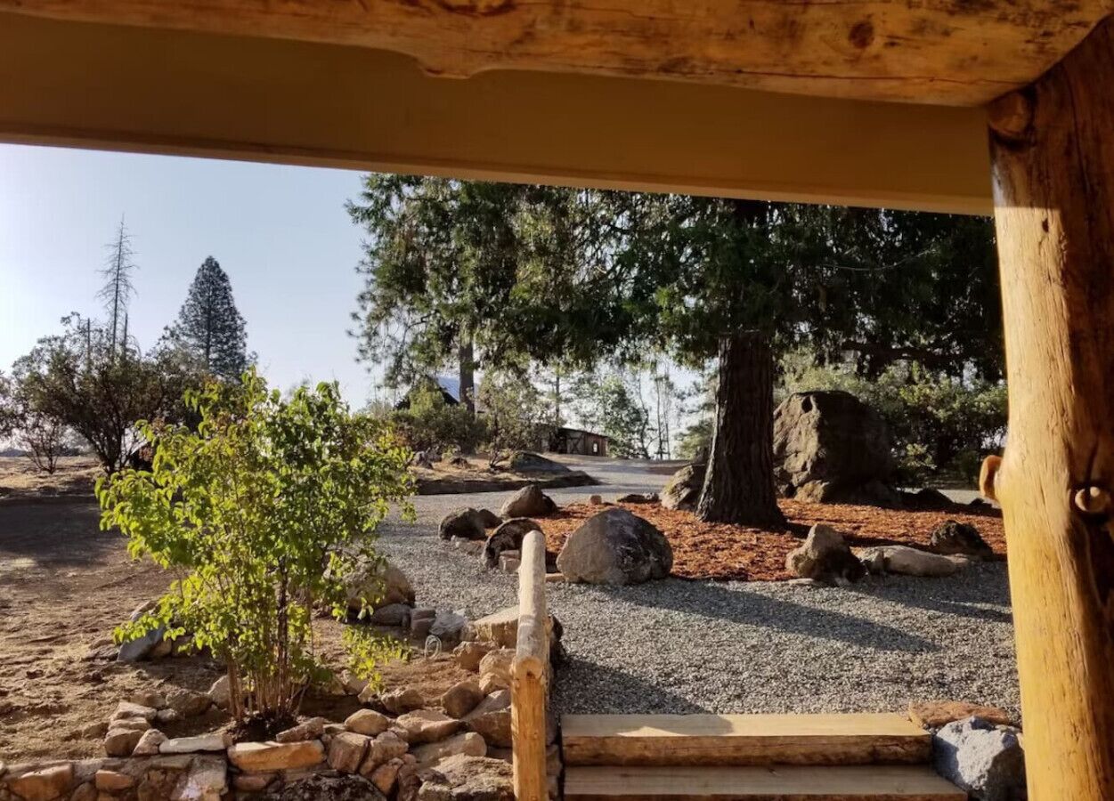 A rustic wooden structure with a gravel path leading to a wooden bench.