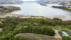 A coastal town with a large lake, surrounded by hills and dense forests.