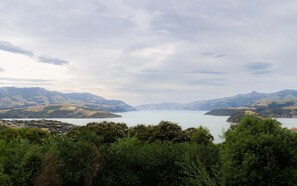 Laaja panoraamanäkymä järvelle, jonka ympärillä on kukkuloita ja tiheää kasvillisuutta.