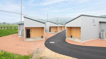A row of industrial-style buildings with a gravel driveway leading to the entrance.