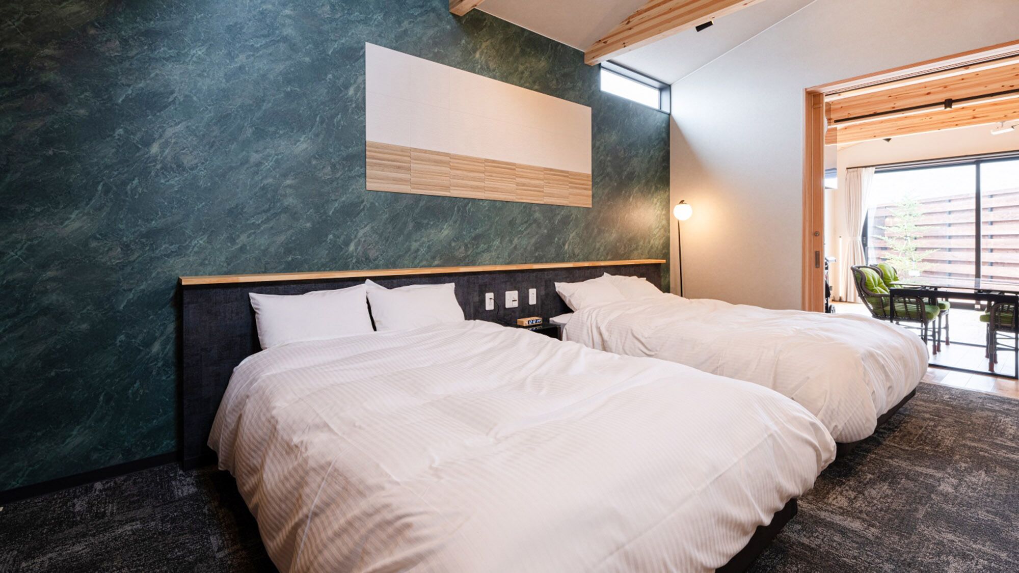 Et moderne hotelværelse med to senge, et stort vindue og udsigt ud