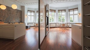 Una cocina moderna con una isla central, ventanas amplias y un comedor con sillas.