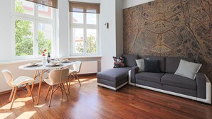Una sala de estar moderna con un sofá, mesa de comedor, sillas y una gran obra de arte abstracta en la pared.