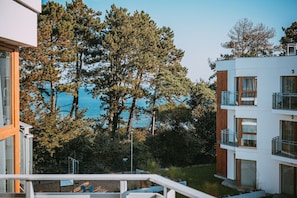 A modern building with multiple balconies, a clear view of the sea, and a lush green landscape. - 2Homerent Piedra | Relax with a Baltic Sea View (Gąski)