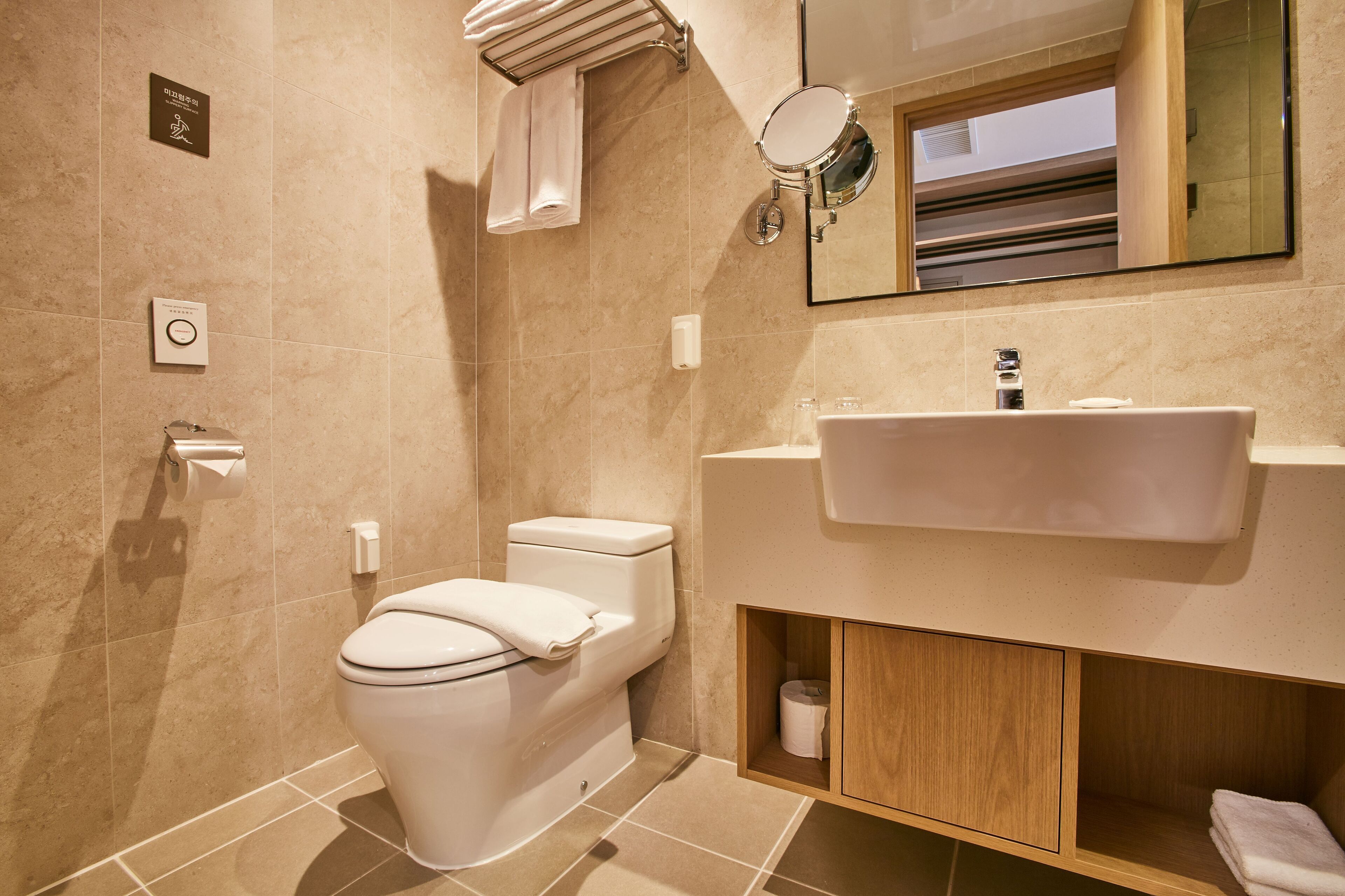 Ein modernes Badezimmer mit Toilette, Waschbecken und Spiegel.