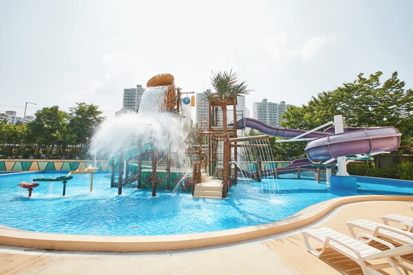 Un parc aquatique doté d’un grand toboggan aquatique, d’une fontaine et d’un espace piscine.