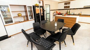 Una cocina moderna con armarios blancos, un comedor negro y sillas negras.