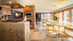 Eine moderne Küche mit Granit-Arbeitsplatten, Edelstahlgeräten und einer Stein-Spritzschutzwand.