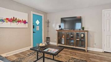A living room with a sofa, coffee table, TV, and a cabinet with glass doors.