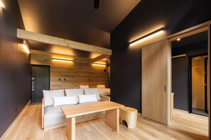 A modern bedroom with a wooden bed, bedside tables, and a bench. - 7c villa & winery (Fujikawaguchiko)