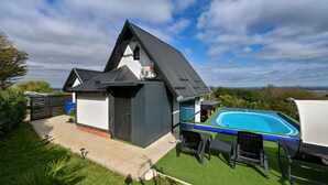 Una casa moderna con piscina, un porche cubierto y vistas al campo.