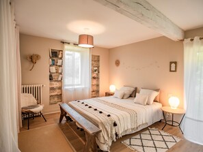 Relax in a well-appointed space with a large bed, wooden bench, and bookshelf.