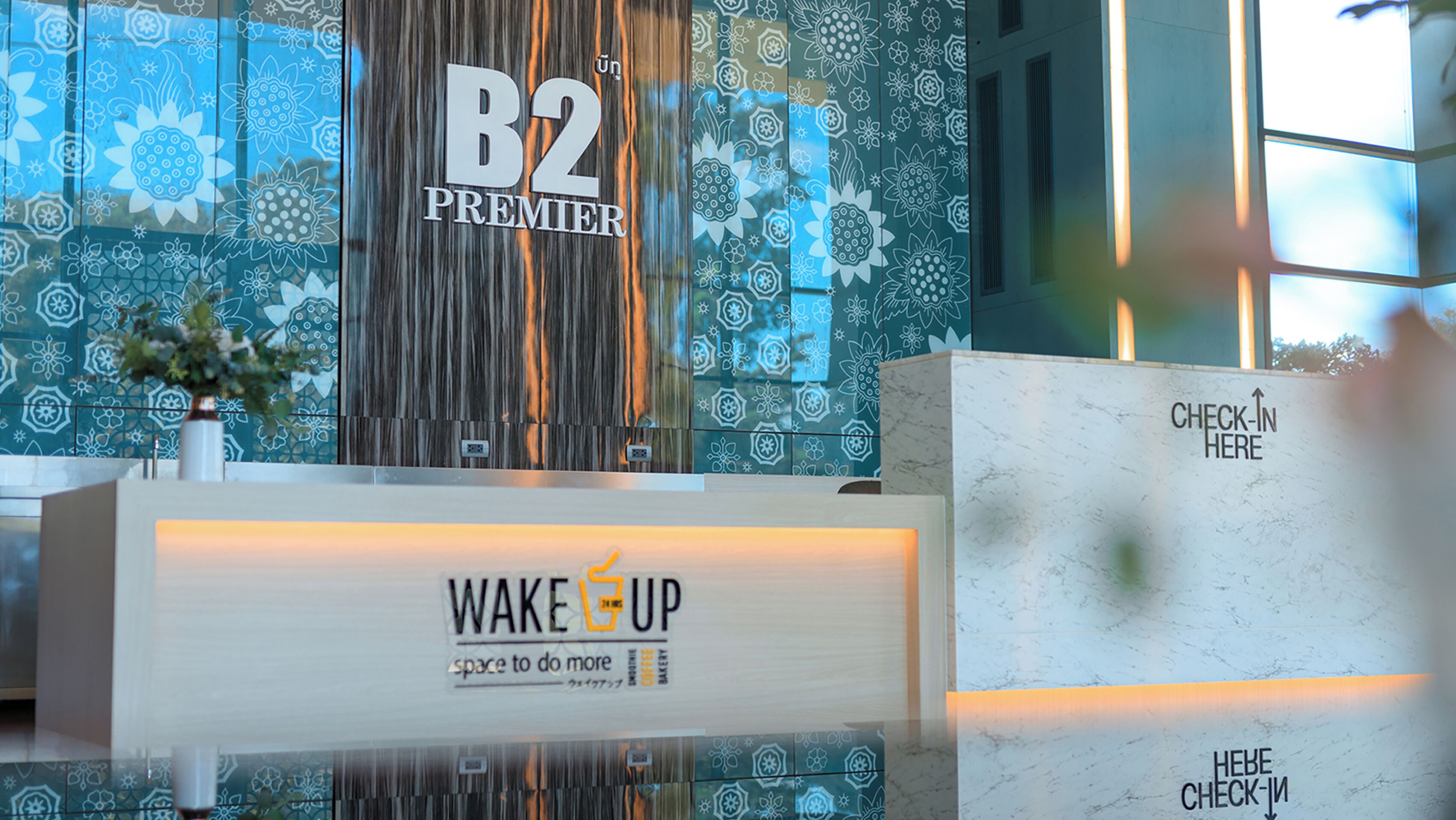 Een receptiegedeelte met een B2 Premier bord, een Wake Up koffiehoek en een receptiebalie.