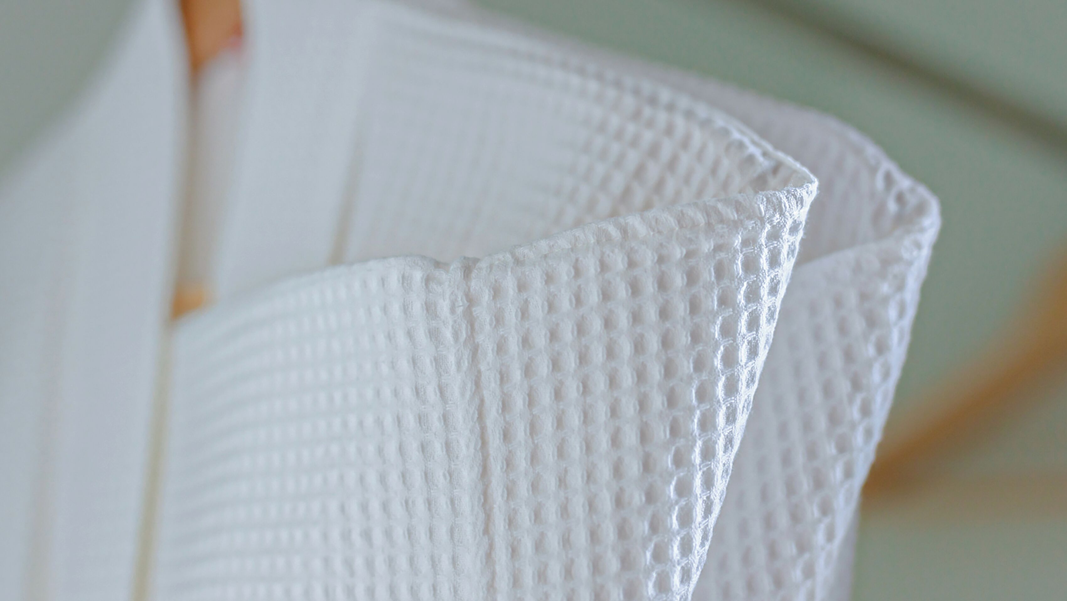 A close-up of a textured white material, likely a fabric or paper.