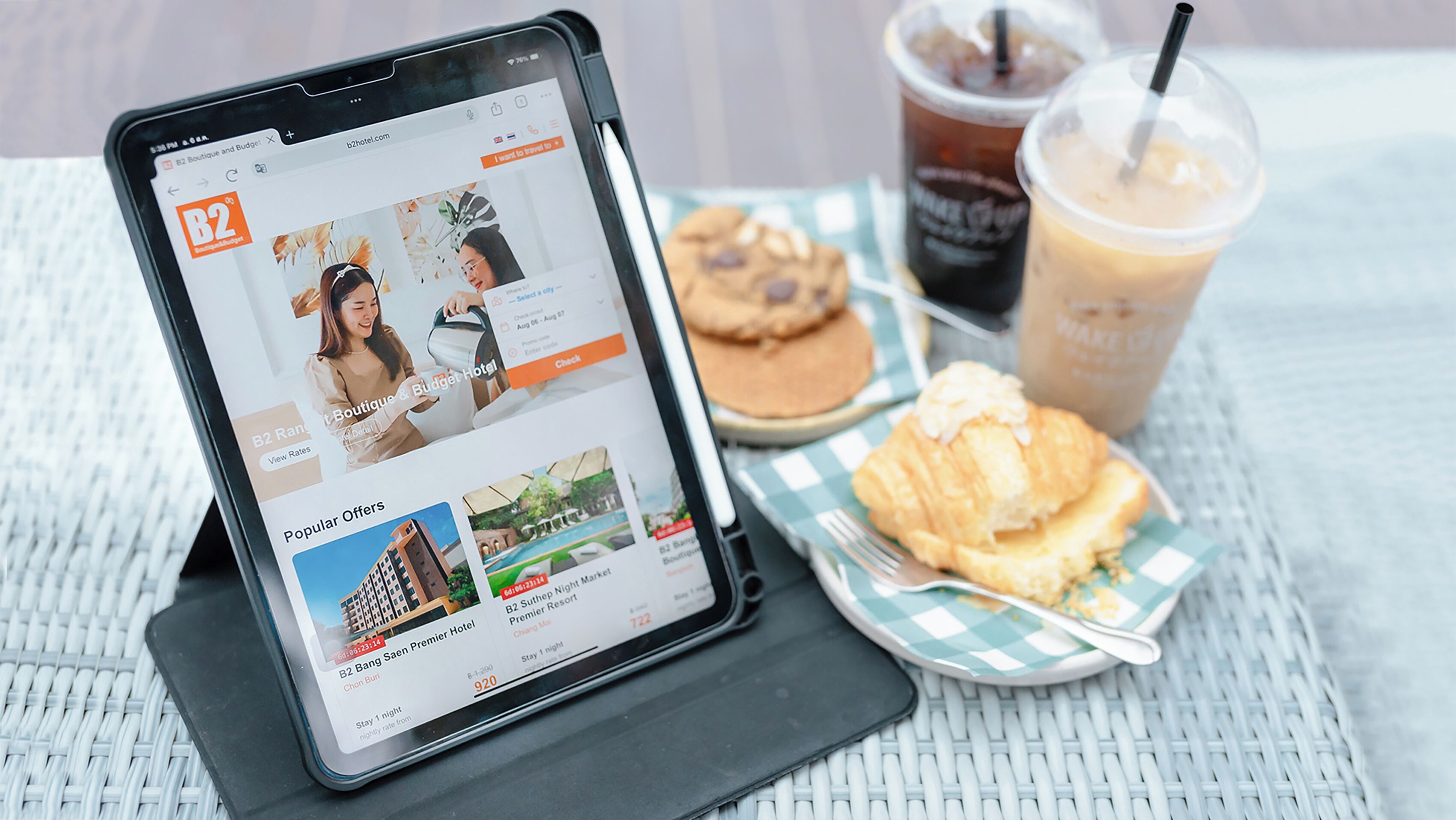 Una tableta mostrando un sitio web de reservas de hotel, destacando el hotel B2 Boutique & Budget, con una sección para ofertas populares e interfaz de reservas.