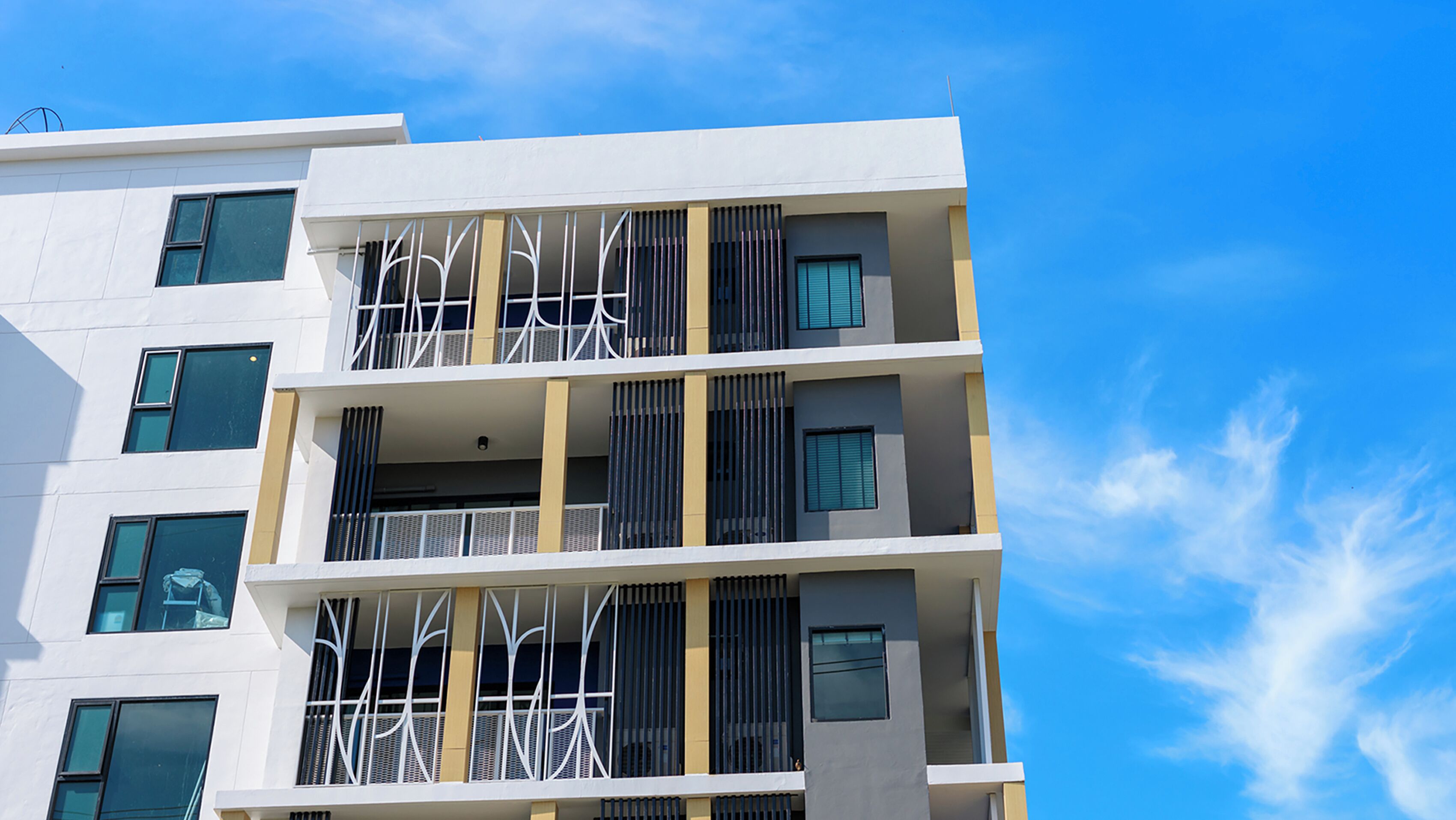 Un edificio de varios pisos con balcones y ventanas amplias.