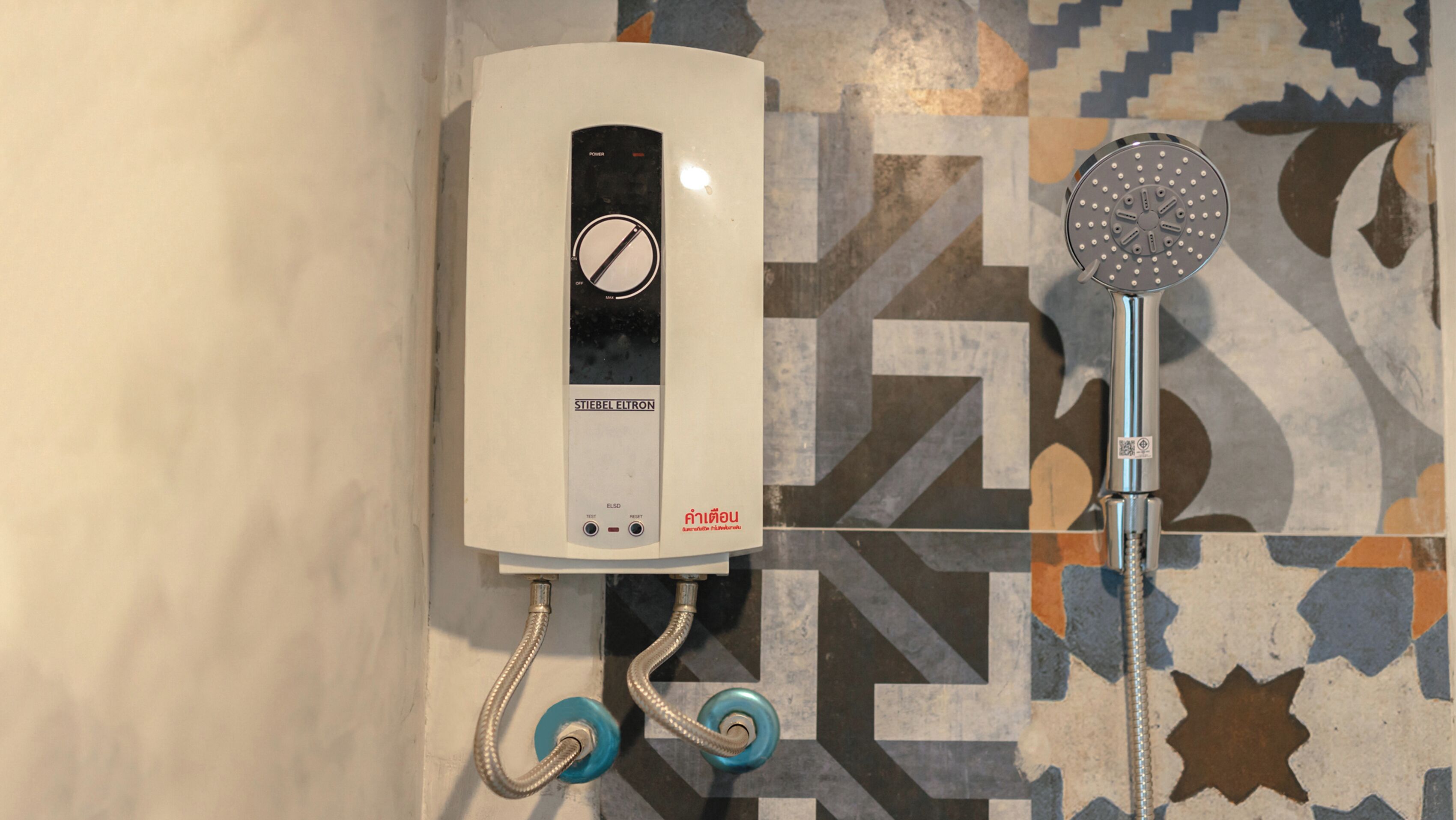 A shower control panel with a hand shower attachment.