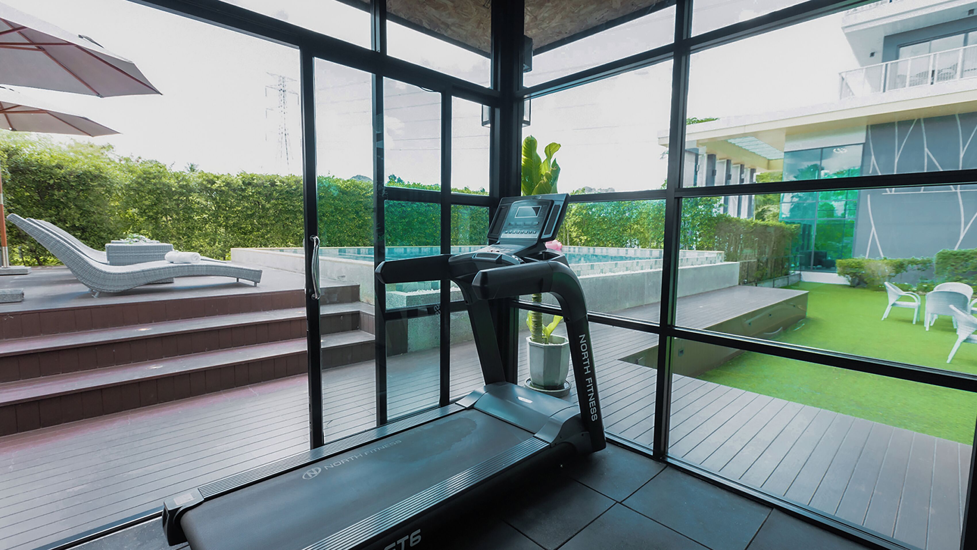 A modern gym with a treadmill, a water bottle, and a chair.