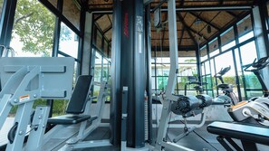 A gym with exercise equipment, large windows, and a thatched roof. - B2 Krabi Premier Hotel (Krabi)