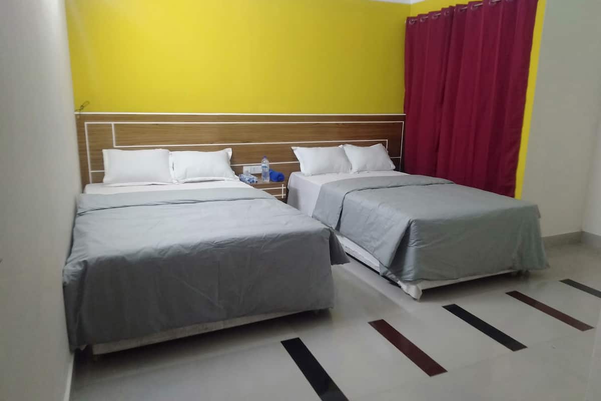 A hotel room with two beds, a wooden headboard, a red curtain, and a tiled floor.