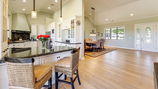 A spacious kitchen with a large island, white cabinetry, and a dining area with a wooden floor and chairs. - Paso Robles Gem w/ On-Site Vineyard: Pets Welcome! (Paso Robles)
