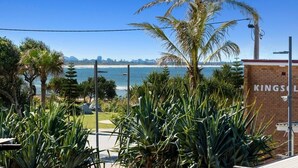 A coastal view with palm trees and a building labeled "KINGSOL." - Ocean View Haven at Paradiso (Kingscliff)
