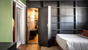 A bedroom with a bed, a wardrobe, and a small bathroom. - Epic Family Getaway | Speakeasy, Pool, Basketball (Glendale)