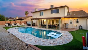 A backyard with a swimming pool, patio furniture, and a covered outdoor dining area. - Epic Family Getaway | Speakeasy, Pool, Basketball (Glendale)