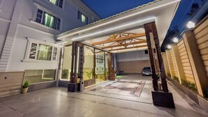 Uma casa moderna com um alpendre coberto, garagem e entrada bem iluminada.