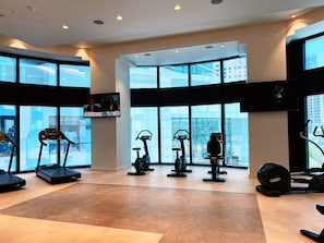 Un gimnasio moderno con cintas de correr, bicicletas estáticas y elípticas.